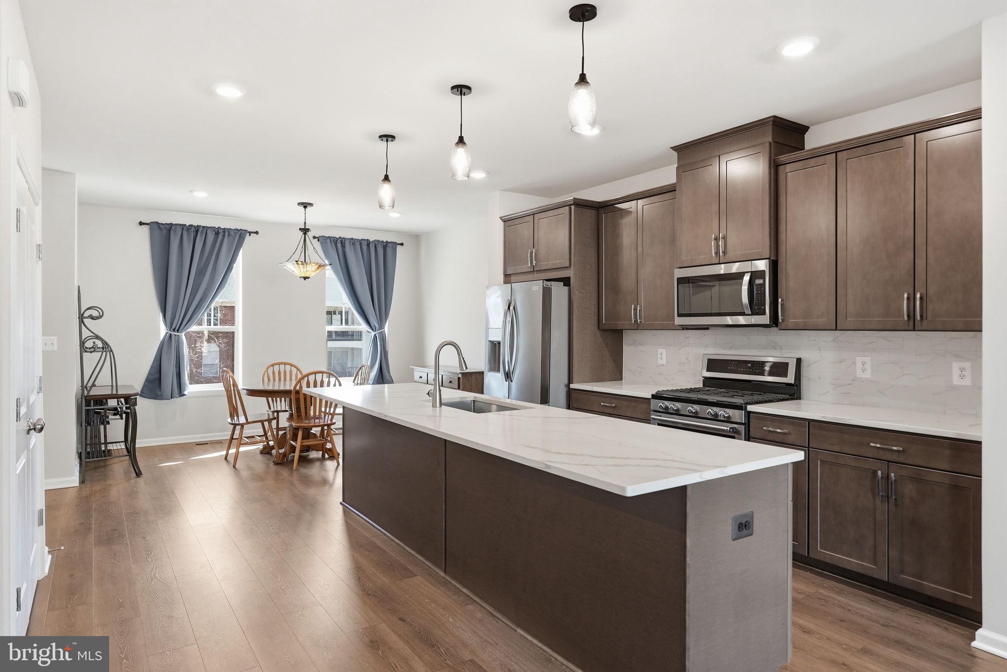 9365 Barnes Loop Manassas, VA 20110 - Photo 4 of 37 a kitchen with kitchen island granite countertop a sink a counter space appliances and cabinets