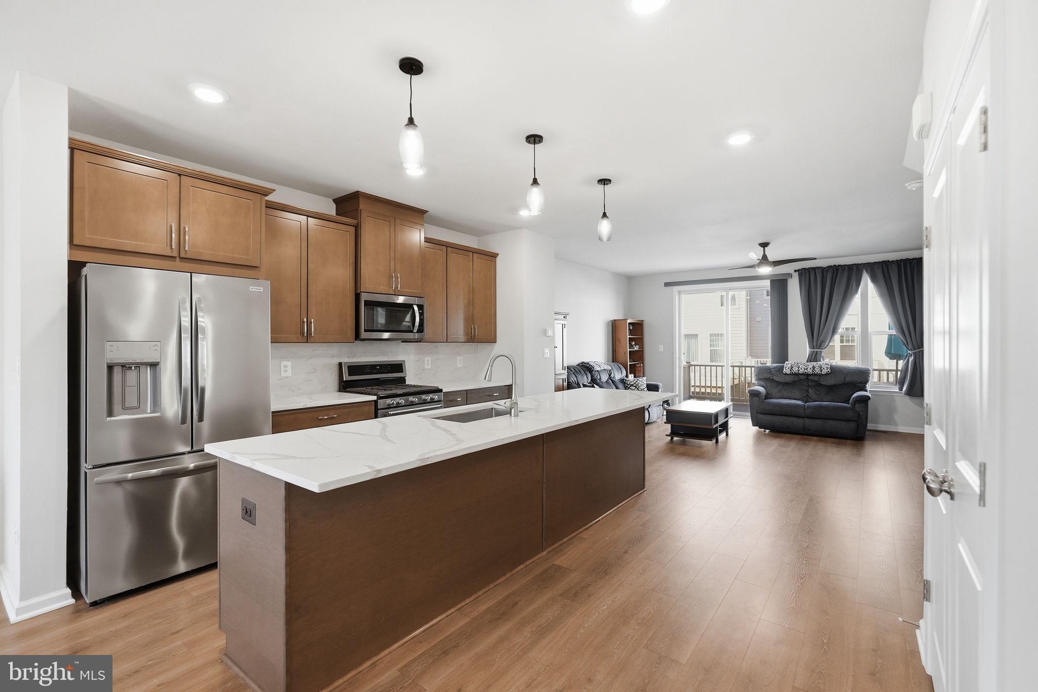 9365 Barnes Loop Manassas, VA 20110 - Photo 5 of 37 a kitchen with refrigerator a sink and chairs