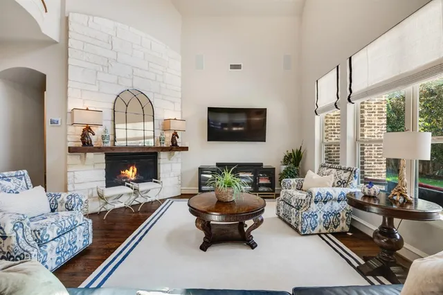 a living room with furniture fireplace and a large window