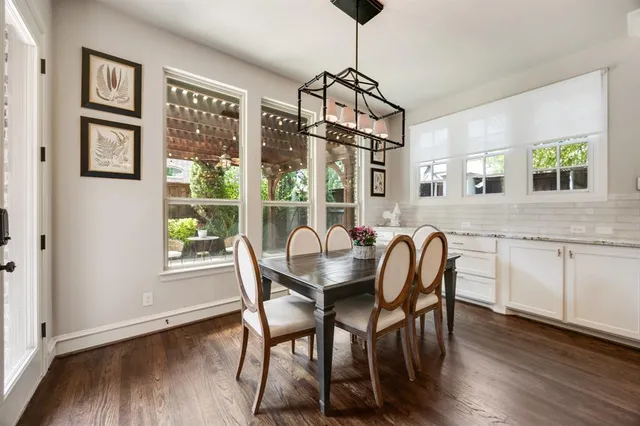 a dining room with furniture a chandelier and wooden floor