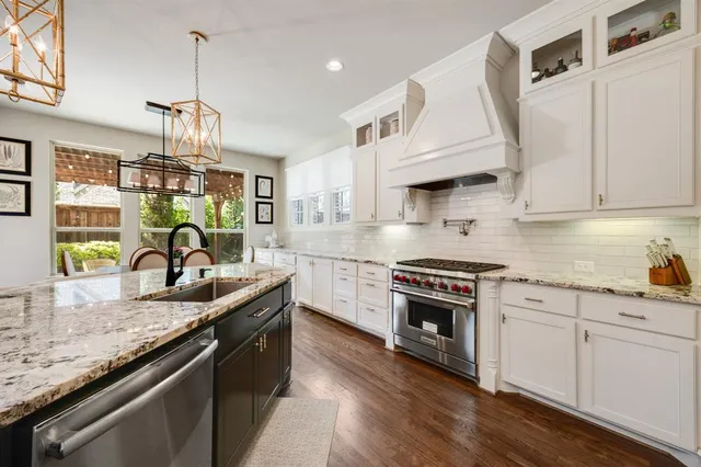 a kitchen with granite countertop a stove and a sink