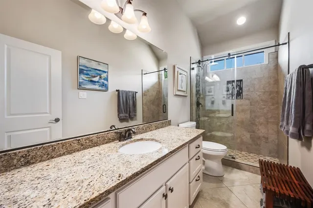 a bathroom with a granite countertop sink toilet and shower