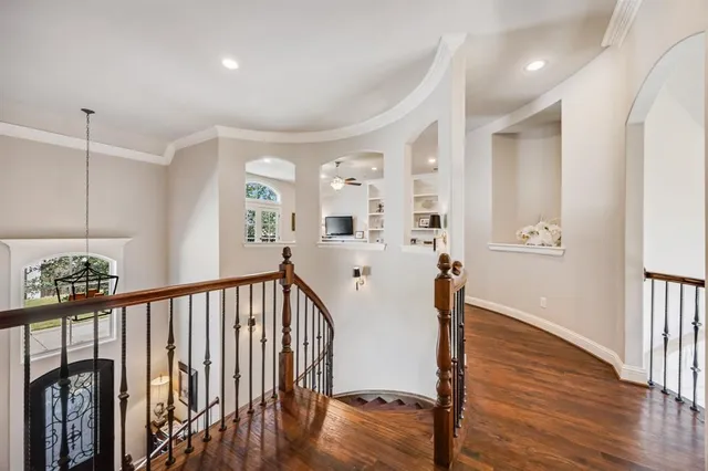 a view of a hallway with wooden floor and stairs