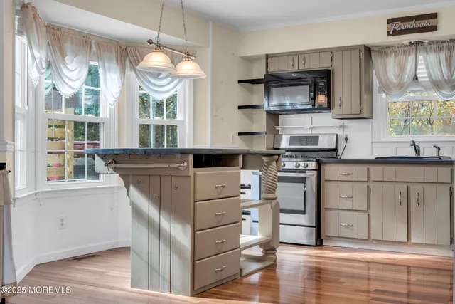 a kitchen with a stove a sink and a window