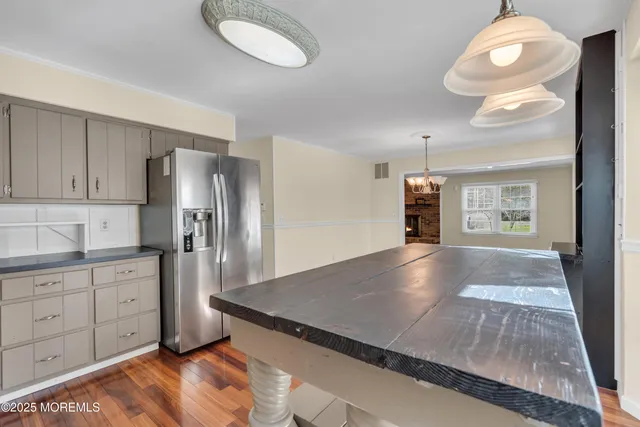 a view of a kitchen with refrigerator and wooden floor