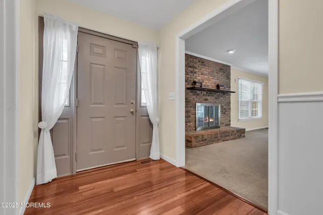 a view of a room with wooden floor and a bathroom