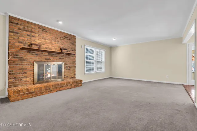 a view of an empty room with a fireplace and a window
