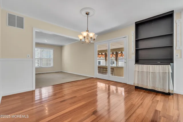 a view of a room with wooden floor staircase and a kitchen space