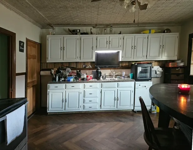 a kitchen with microwave a sink and cabinets