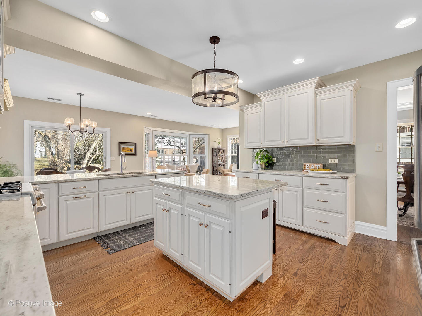 207 Ravine Road Hinsdale, IL 60521 - Photo 6 of 35 a kitchen with white cabinets stainless steel appliances and wooden floor