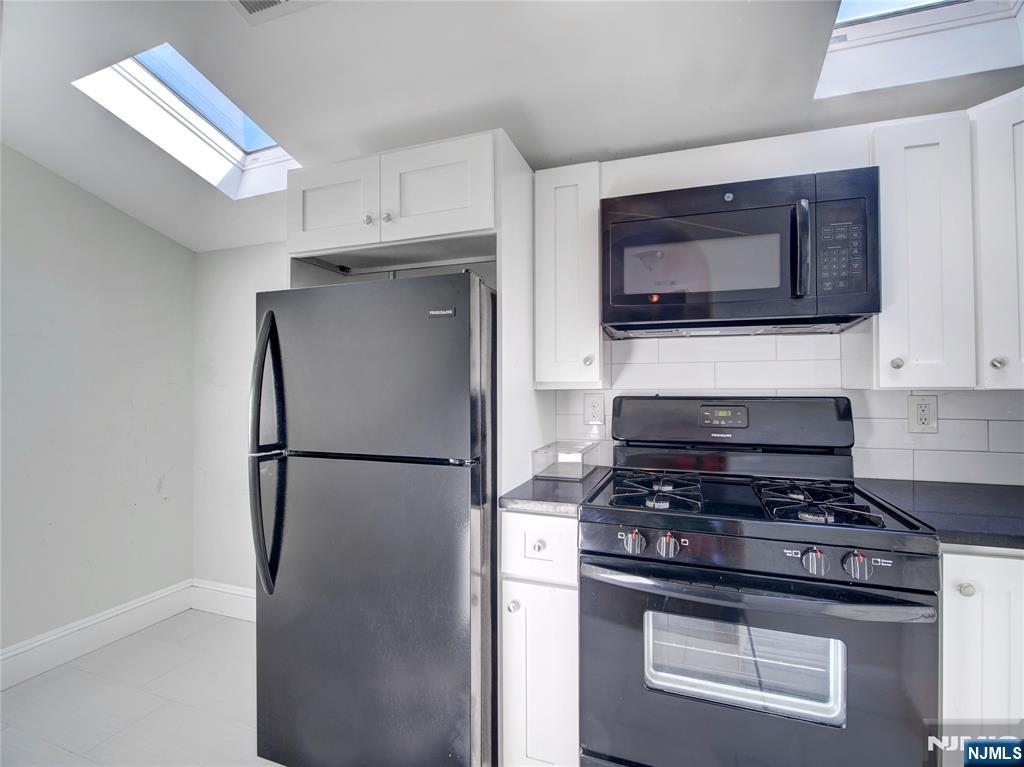222 Lafayette Avenue, Unit 2 Lyndhurst, NJ 07071 - Photo 3 of 15 a kitchen with cabinets and stainless steel appliances