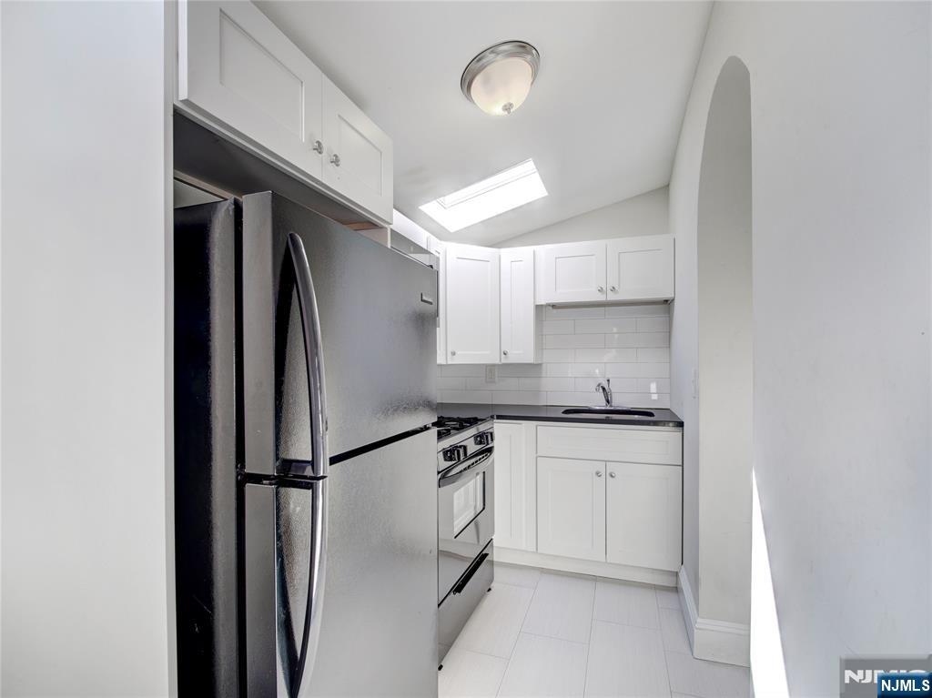 222 Lafayette Avenue, Unit 2 Lyndhurst, NJ 07071 - Photo 4 of 15 a kitchen with stainless steel appliances granite countertop a sink a stove a refrigerator and white cabinets