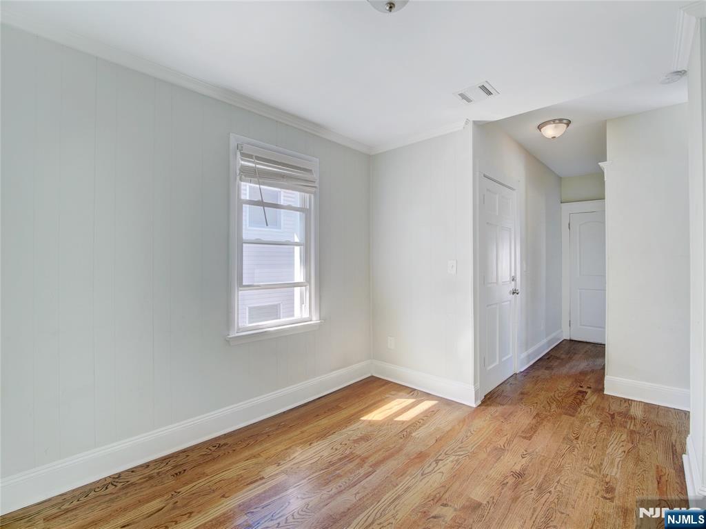 222 Lafayette Avenue, Unit 2 Lyndhurst, NJ 07071 - Photo 5 of 15 a view of an empty room with wooden floor and a window