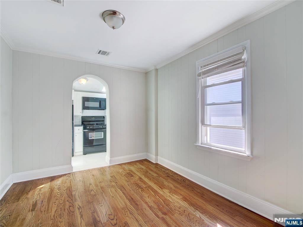 222 Lafayette Avenue, Unit 2 Lyndhurst, NJ 07071 - Photo 6 of 15 an empty room with wooden floor and windows