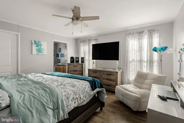 a bedroom with a bed a couch and a flat screen tv