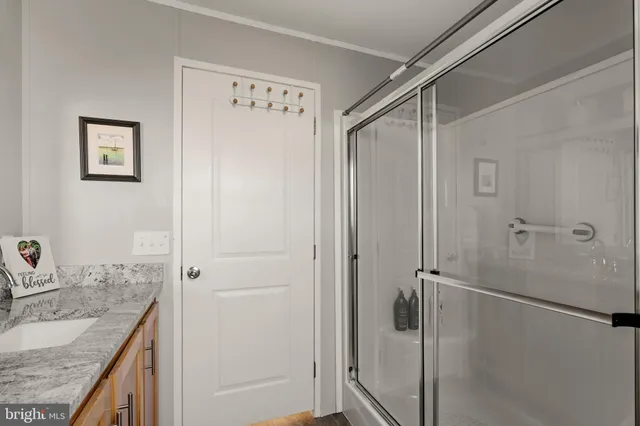 a bathroom with a granite countertop sink mirror and shower