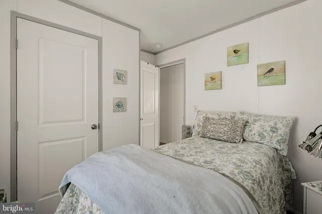 a bedroom with a bed and painting on the wall