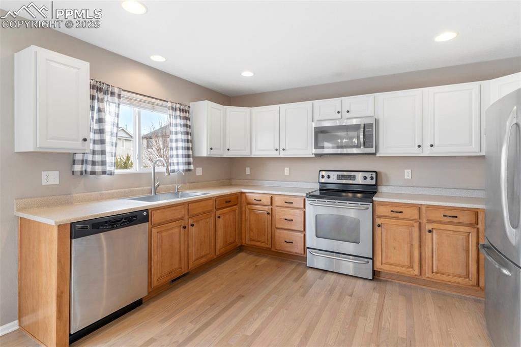 7710 Sistine Lane Fountain, CO 80817 - Photo 4 of 33 a kitchen with stainless steel appliances granite countertop a stove a sink and white cabinets