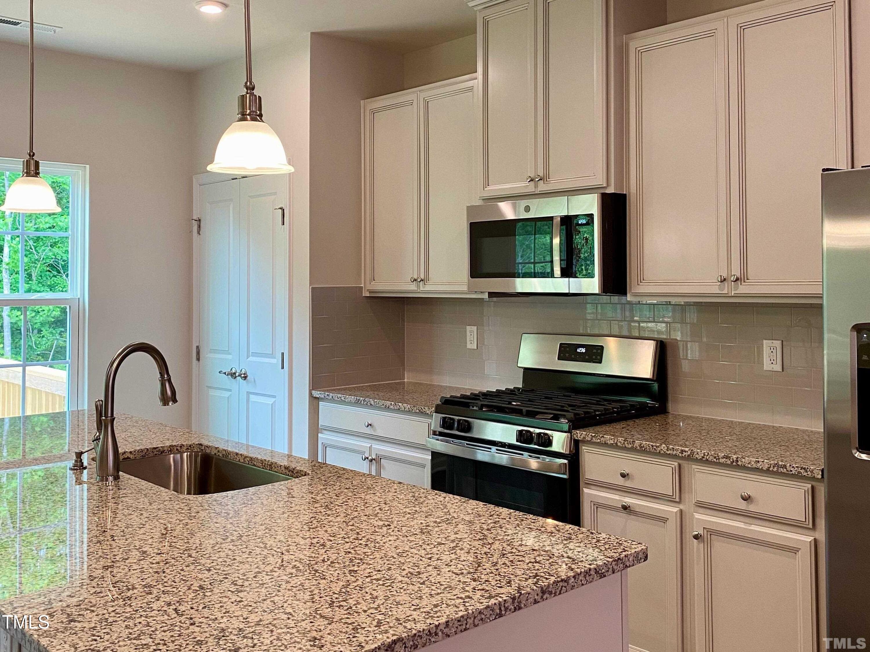 6627 Pathfinder Way Raleigh, NC 27616 - Photo 5 of 35 a kitchen with stainless steel appliances granite countertop a stove a sink and a white cabinets