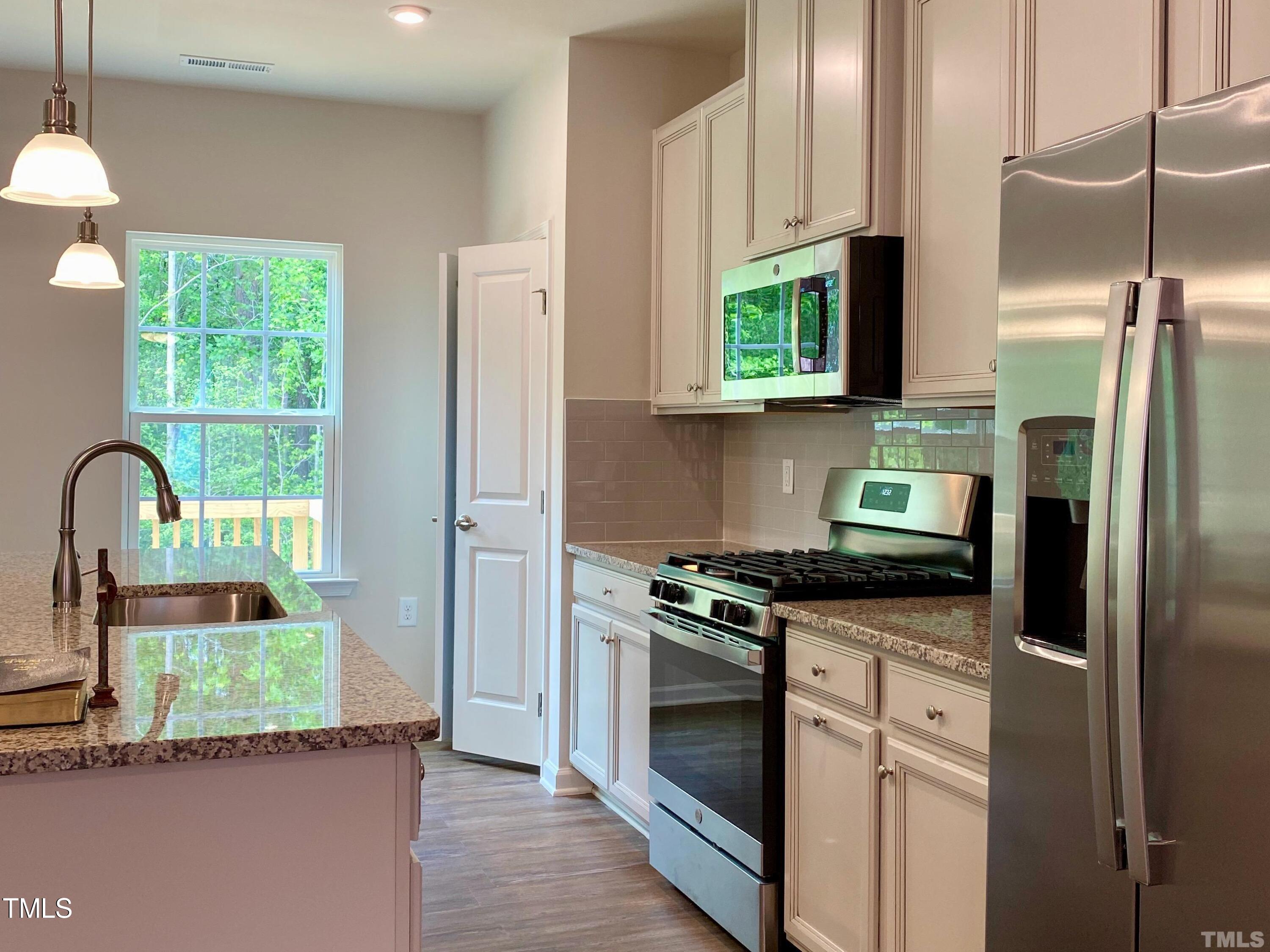 6627 Pathfinder Way Raleigh, NC 27616 - Photo 10 of 35 a kitchen with stainless steel appliances granite countertop a refrigerator sink and stove
