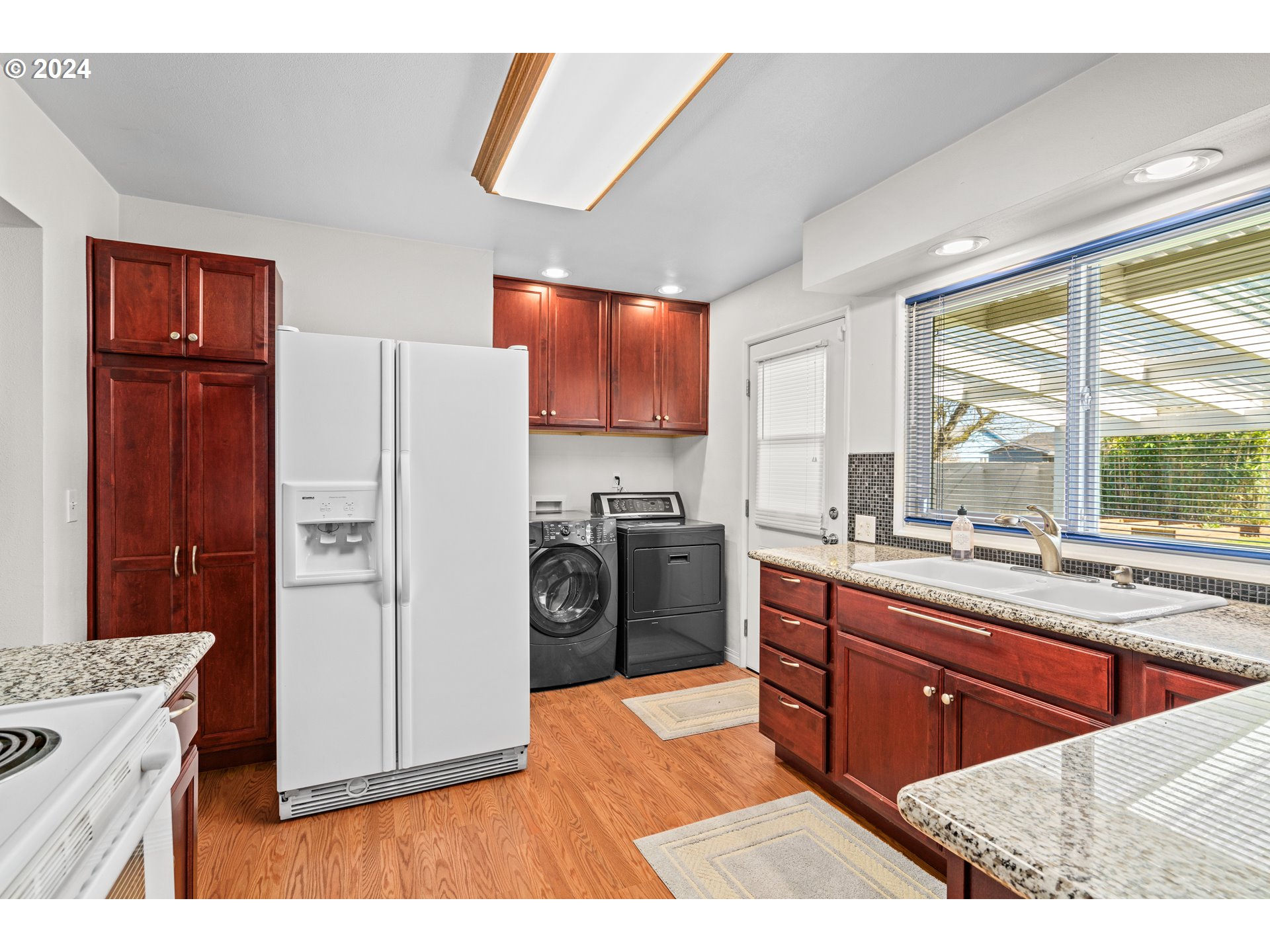 1841 Market Street Springfield, OR 97477 - Photo 10 of 23 a kitchen with stainless steel appliances kitchen island granite countertop a refrigerator a sink dishwasher and wooden cabinets