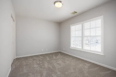 an empty room with windows and closet