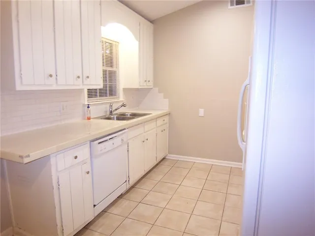 a white refrigerator freezer and a stove sitting inside of a kitchen