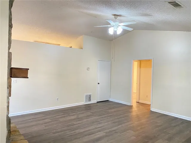a view of a livingroom with a fireplace wooden floor and windows