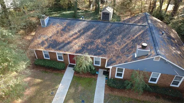 a view of a house with backyard and trees