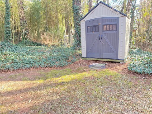 an empty room with wooden floor fireplace and windows