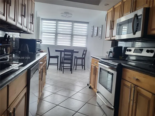 a kitchen with stainless steel appliances granite countertop a stove a sink and a microwave