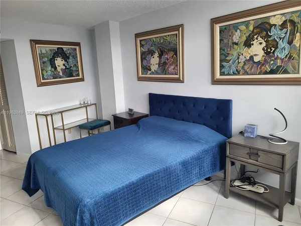 a bedroom with a bed and a painting on the wall