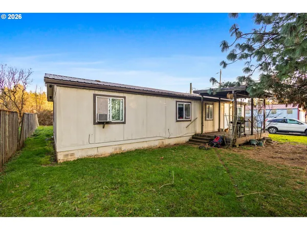 a view of a house with backyard and sitting area