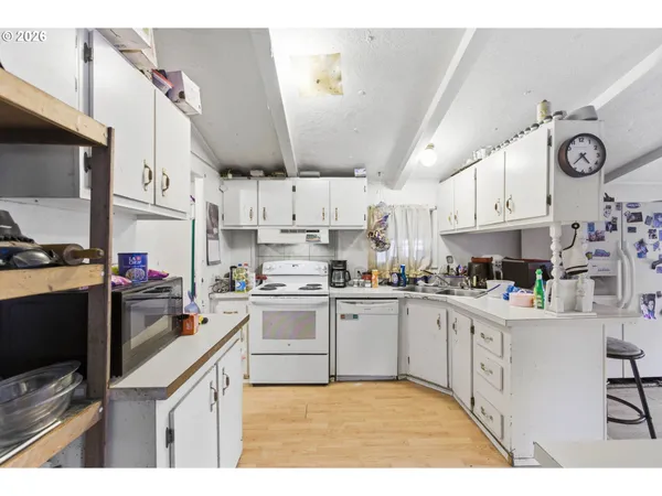 a kitchen with stainless steel appliances granite countertop a sink a stove and cabinets