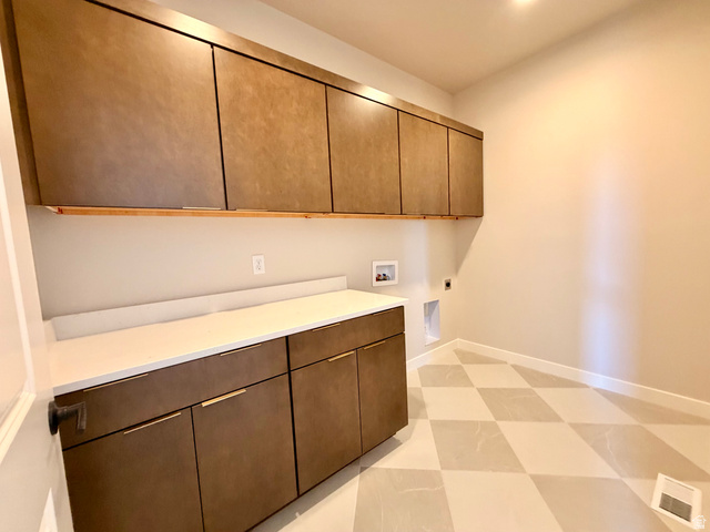 5885 Canyon Rim Road, Unit 624 Lehi, UT 84048 - Photo 13 of 17 Modern utility room featuring extensive cabinetry, bright white countertops, and checkerboard floor tiling