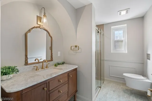 a bathroom with a granite countertop sink a toilet and a mirror