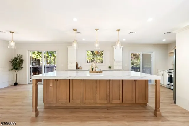 a view of kitchen with stainless steel appliances granite countertop cabinets and wooden floor