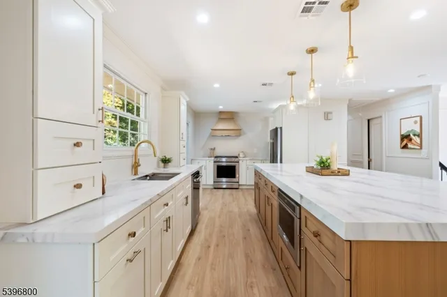 a large kitchen with kitchen island a large counter space a sink appliances and cabinets