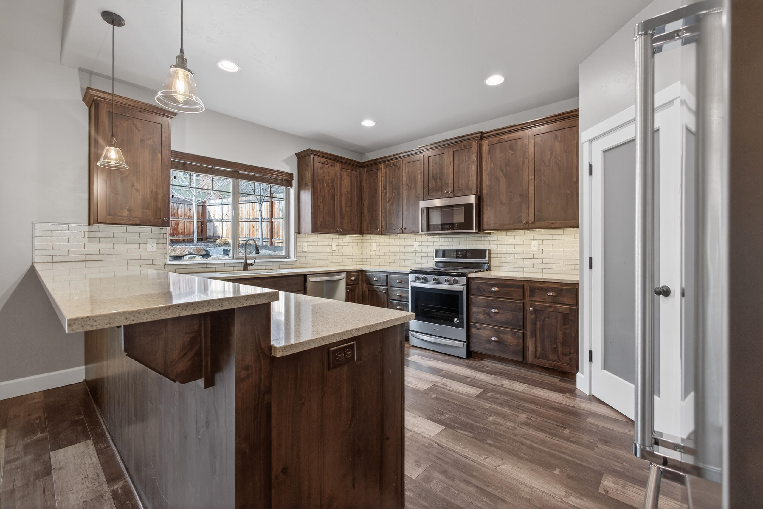 2793 Southwest 33rd Street Redmond, OR 97756 - Photo 10 of 44 a kitchen with kitchen island granite countertop a sink appliances cabinets and a counter top space