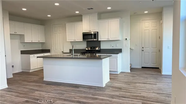 a kitchen with kitchen island white cabinets stainless steel appliances