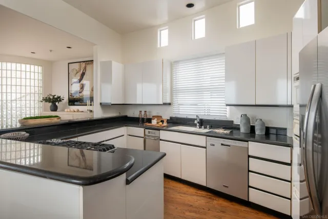 a living room with stainless steel appliances kitchen island granite countertop furniture and a large window