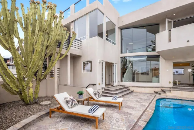 a view of a patio with couches table and chairs with wooden floor and fence