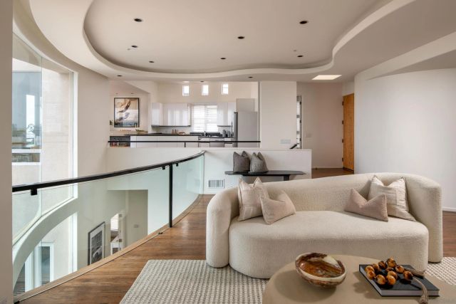 a living room with furniture potted plant and a large window