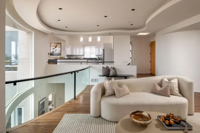 a living room with furniture potted plant and a large window