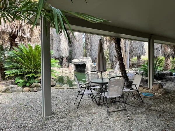 a view of a patio with table and chairs next to a yard