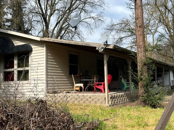 a view of house with a yard and sitting area