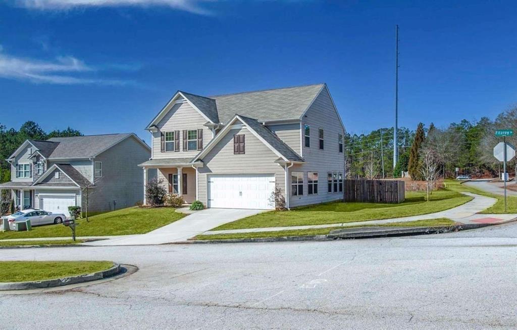 a view of a big house with a big yard and large trees