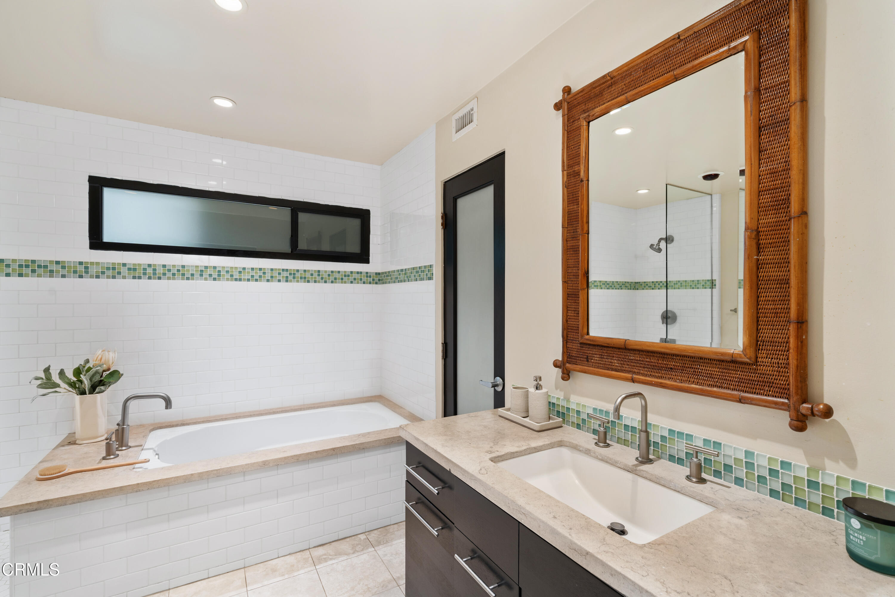 11915 Gorham Avenue, Unit 3 Los Angeles, CA 90049 - Photo 18 of 30 a bathroom with a granite countertop sink a large mirror and a bathtub