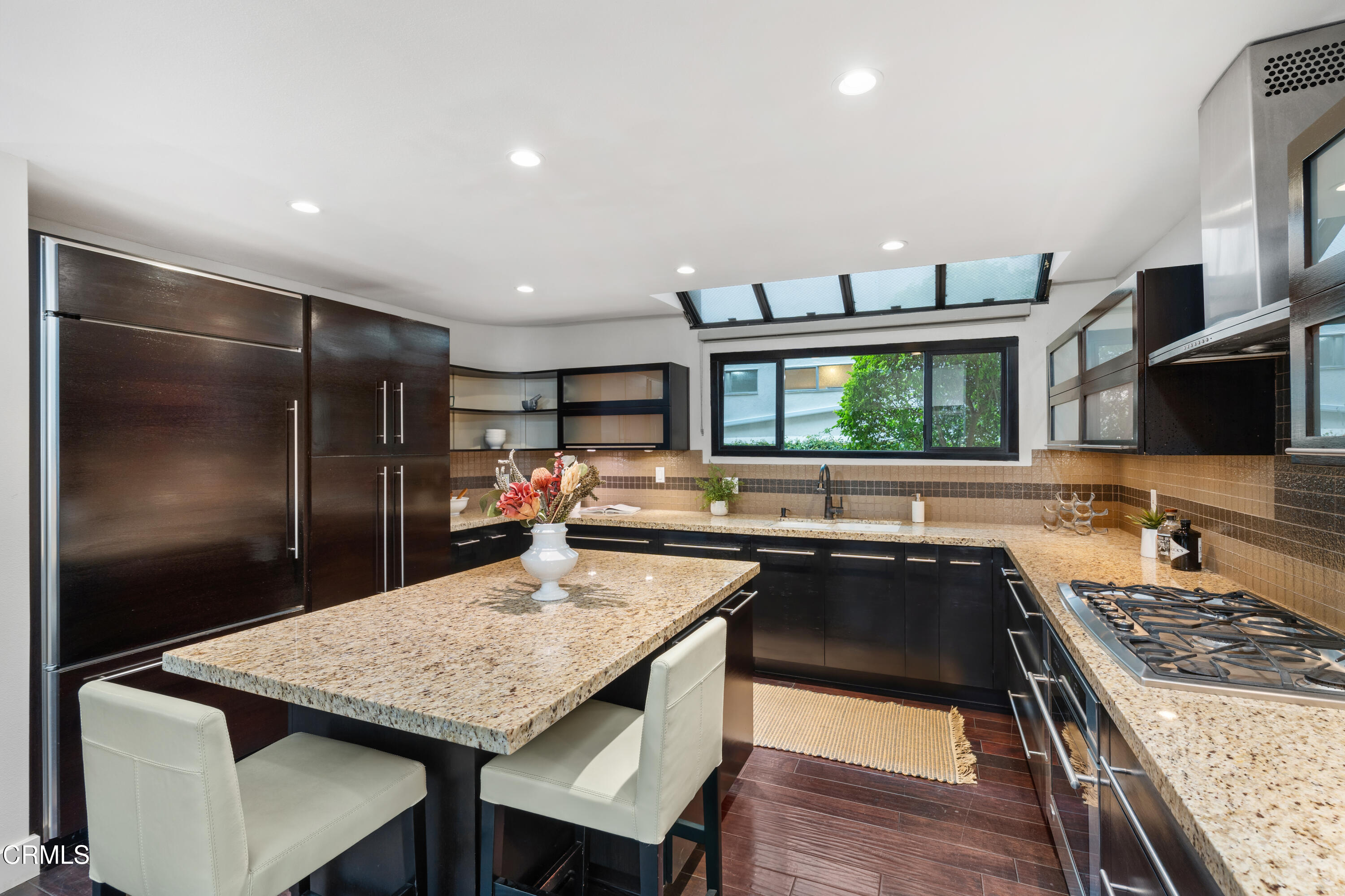 11915 Gorham Avenue, Unit 3 Los Angeles, CA 90049 - Photo 10 of 30 a kitchen with a stove a refrigerator and a dining table with wooden floor