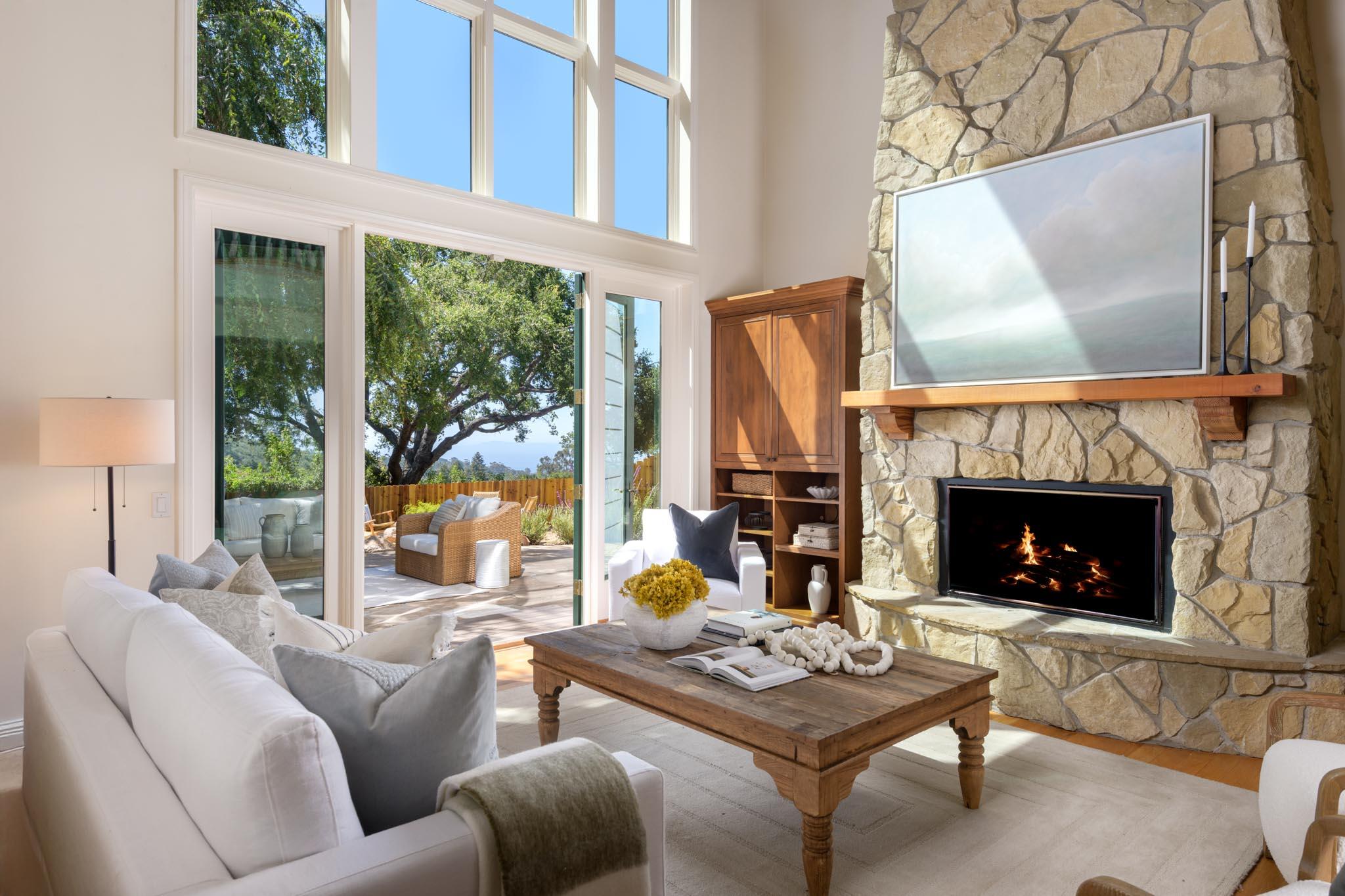 1444 Tunnel Road Santa Barbara, CA 93105 - Photo 1 of 24 a living room with furniture a fireplace and a large window